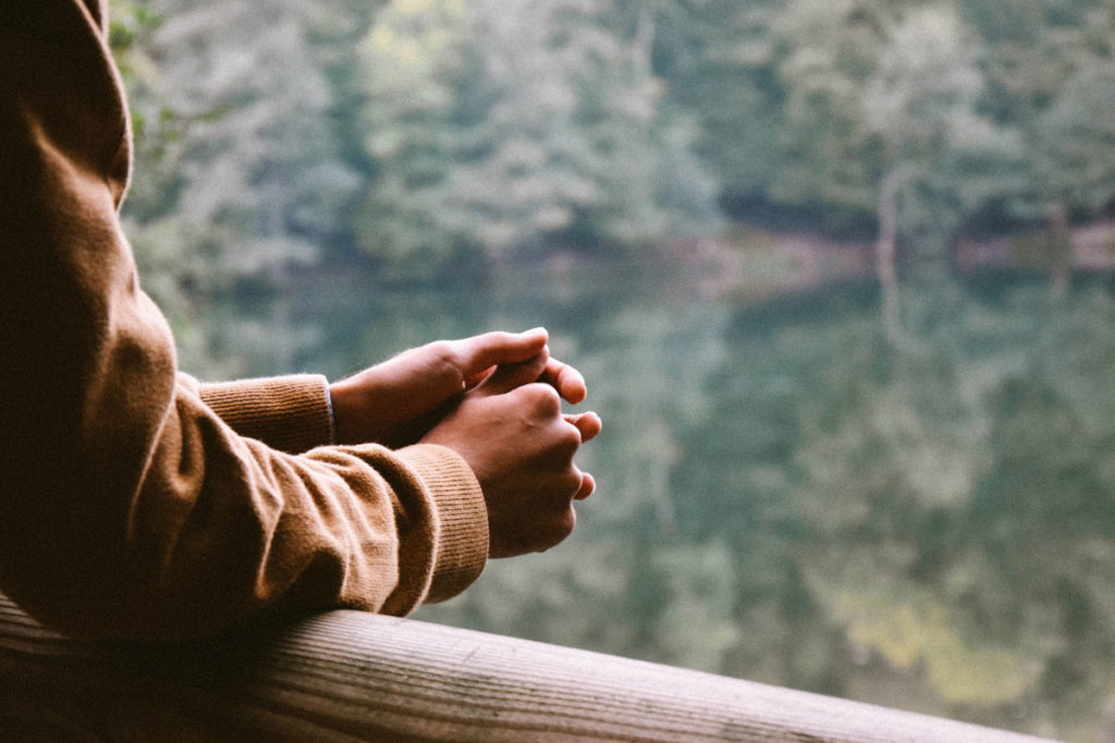 Someone thinking in front of a lake.