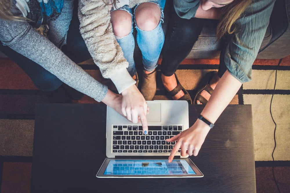 3 people pointing at a screen